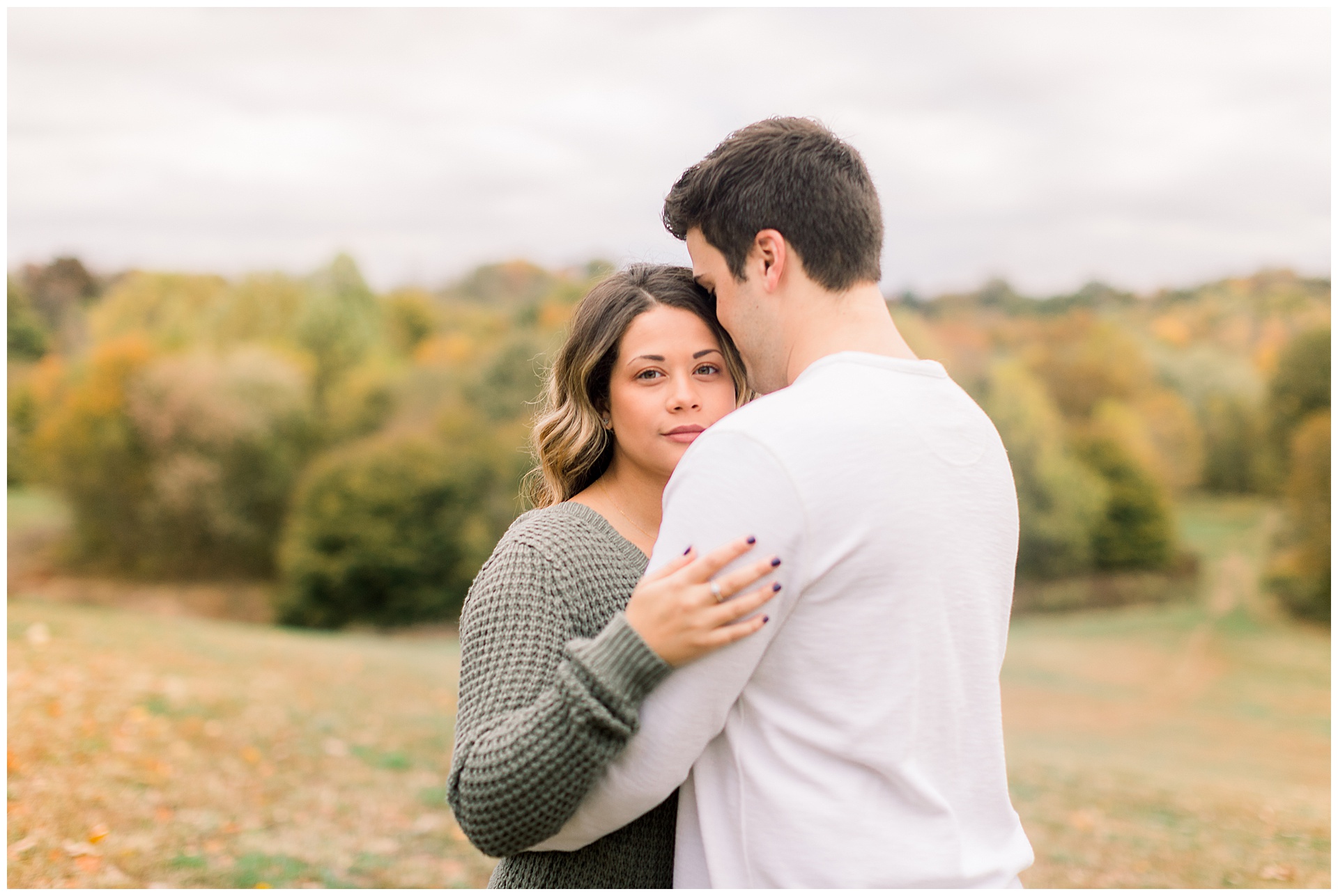 cute couple admires each other during fall engagement session